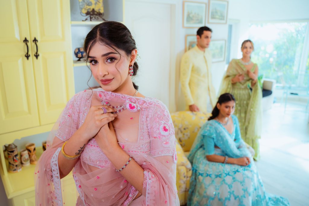 A group of adults elegantly dressed in traditional attire indoors, showcasing vibrant colors and intricate designs.